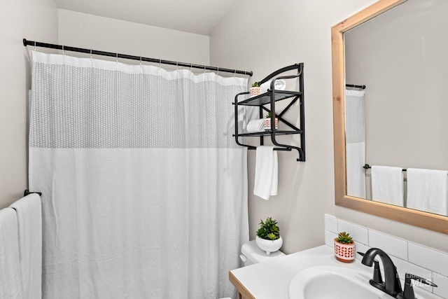 bathroom with curtained shower, vanity, toilet, and decorative backsplash