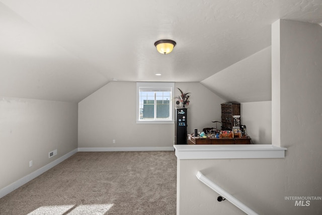 bonus room with carpet floors and lofted ceiling