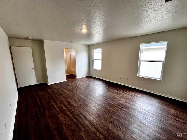 spare room with dark hardwood / wood-style flooring and a textured ceiling