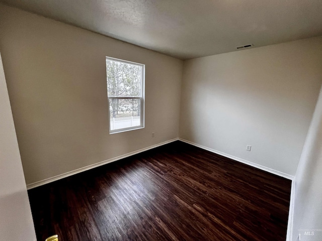 unfurnished room with dark wood-type flooring