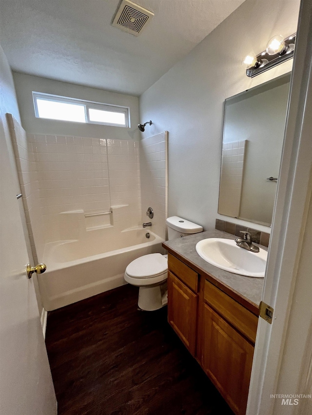 full bathroom featuring wood-type flooring, tub / shower combination, vanity, and toilet