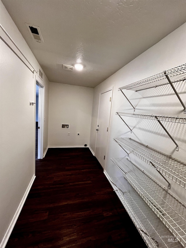 hall with dark hardwood / wood-style flooring and a textured ceiling