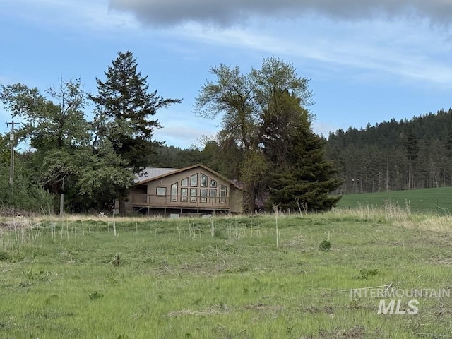 view of yard with a view of trees and a deck
