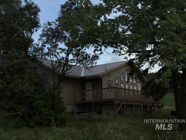 back of house featuring a deck and metal roof