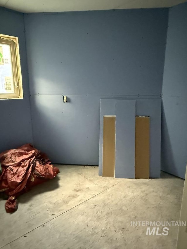unfurnished bedroom with concrete flooring