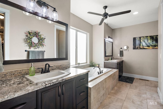 bathroom with ceiling fan, vanity, tile patterned floors, and tiled tub