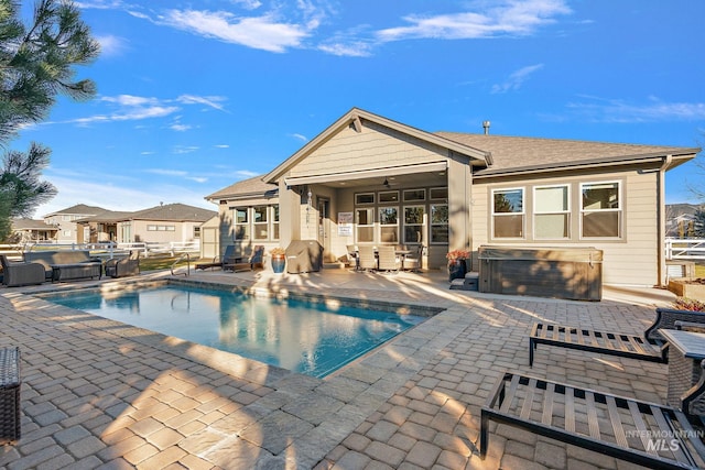 view of swimming pool featuring ceiling fan, a hot tub, and a patio