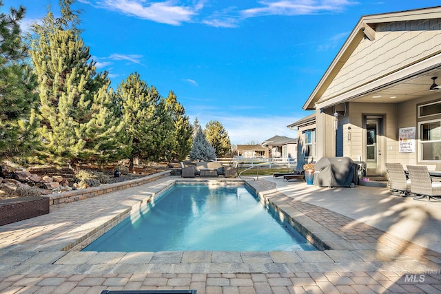 view of swimming pool featuring grilling area and a patio