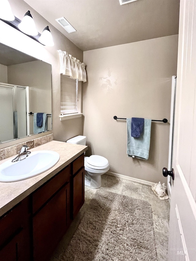 bathroom featuring vanity, toilet, and an enclosed shower