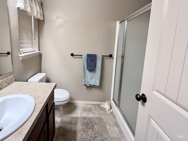 bathroom featuring tile patterned flooring, vanity, toilet, and a shower with door