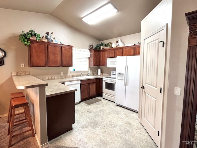 kitchen with kitchen peninsula, a kitchen bar, white appliances, vaulted ceiling, and sink