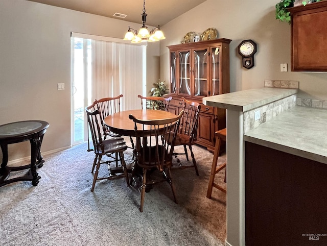 dining area featuring carpet flooring, lofted ceiling, and a notable chandelier