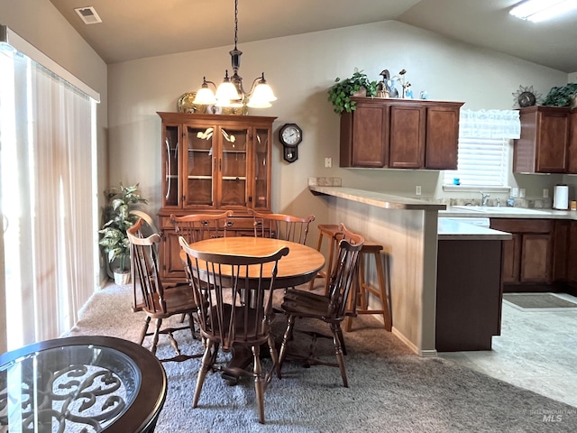 carpeted dining space with lofted ceiling, sink, and an inviting chandelier