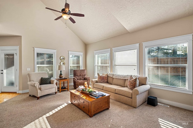 living room with a textured ceiling, light hardwood / wood-style flooring, high vaulted ceiling, and ceiling fan