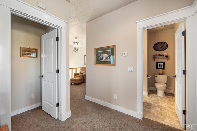 corridor featuring carpet floors and a textured ceiling