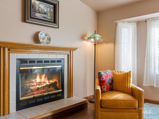 sitting room with light wood-type flooring and a tile fireplace