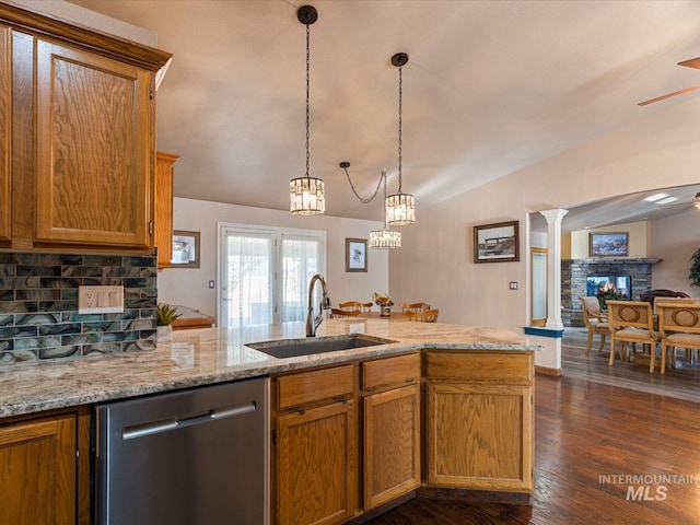 kitchen featuring ornate columns, lofted ceiling, dark wood-type flooring, dishwasher, and sink