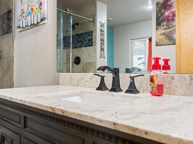 bathroom with tiled shower and vanity