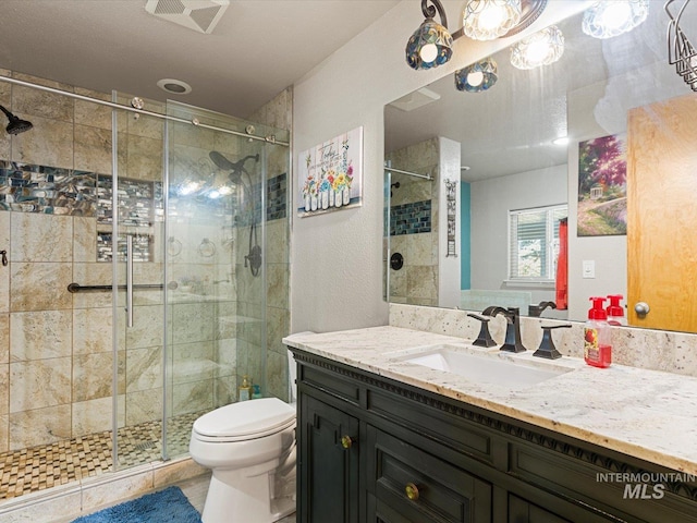 bathroom with toilet, tile patterned floors, vanity, and a shower with door