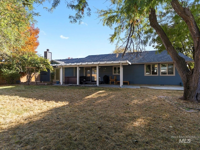 back of house with a patio and a lawn