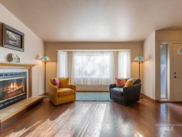 sitting room with a fireplace, dark hardwood / wood-style flooring, and a textured ceiling