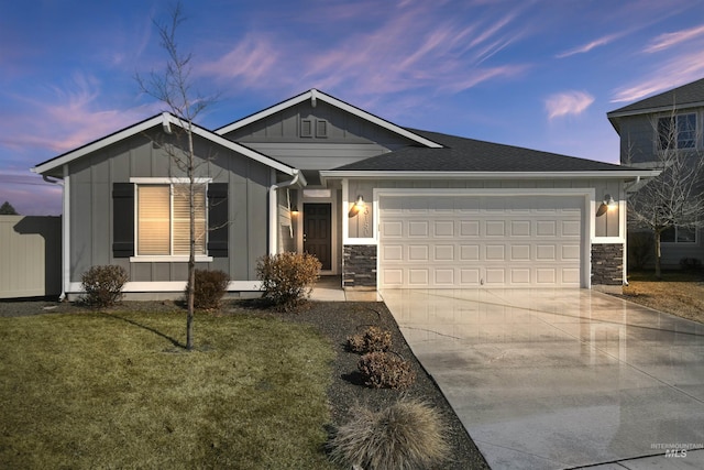 view of front of home featuring driveway, stone siding, a garage, and board and batten siding