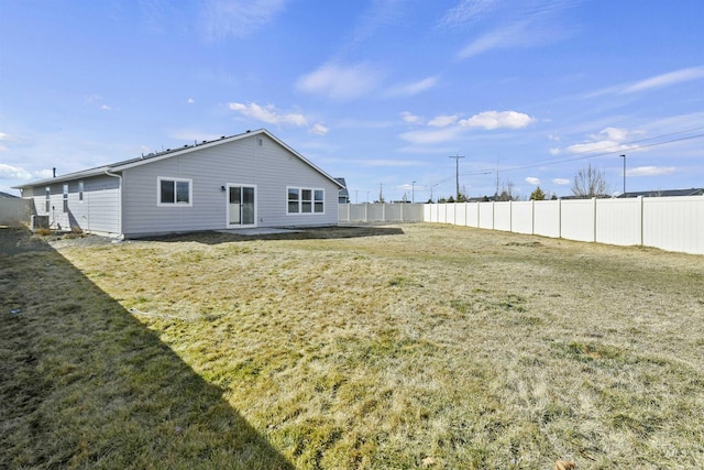 back of property featuring a lawn and fence