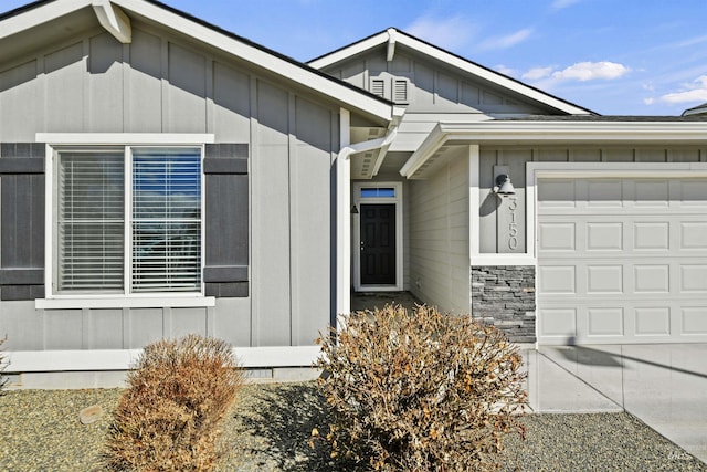 entrance to property with board and batten siding, crawl space, and an attached garage