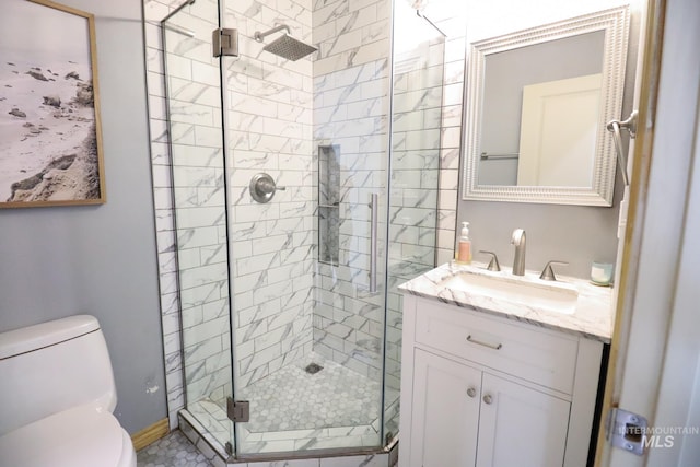bathroom featuring vanity, baseboards, a stall shower, and toilet