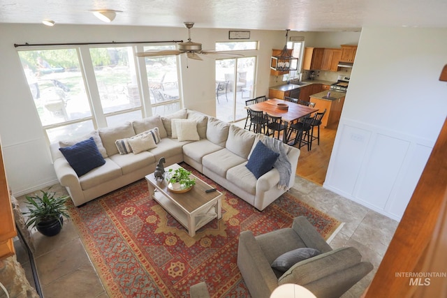 living area with plenty of natural light, a ceiling fan, and light tile patterned flooring