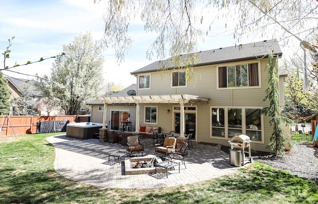 rear view of property with a hot tub, fence, an outdoor fire pit, a yard, and a pergola