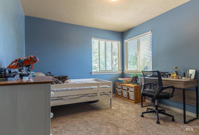 carpeted bedroom featuring baseboards and a textured ceiling