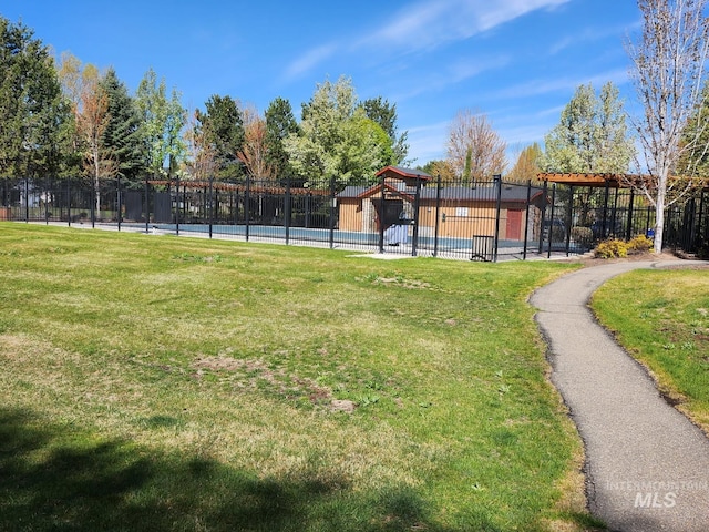 view of yard featuring fence and a fenced in pool