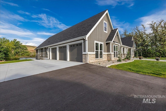 3800 Birch Ln, Emmett, ID 83617 - view of front of house with board and batten siding, stone siding, asphalt driveway, cooling unit, and a front yard