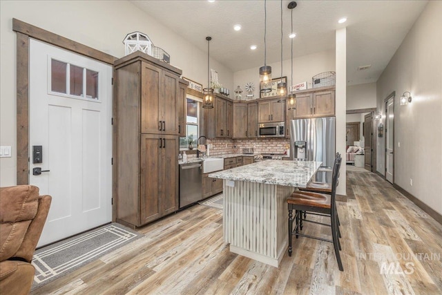 3800 Birch Ln, Emmett, ID 83617 - kitchen featuring stainless steel appliances, light wood-style flooring, open floor plan, light stone countertops, and recessed lighting