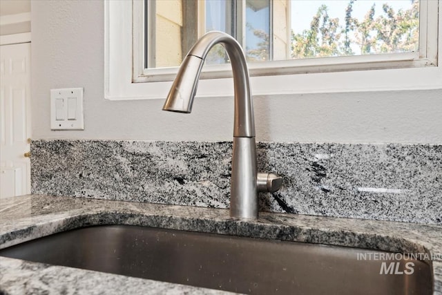 interior details featuring stone counters and a sink
