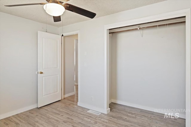 unfurnished bedroom featuring a closet, ceiling fan, light wood finished floors, baseboards, and visible vents