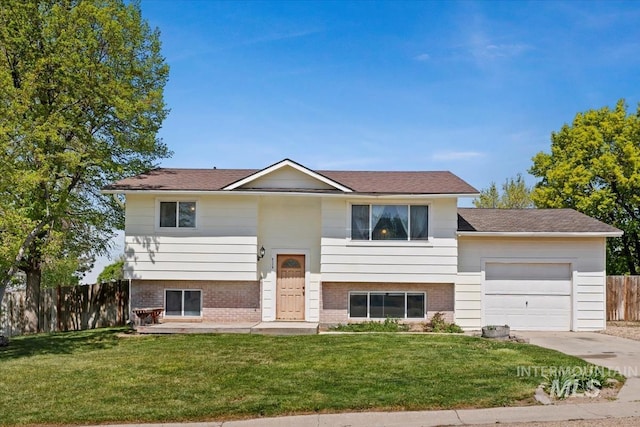 bi-level home featuring fence, concrete driveway, brick siding, and an attached garage