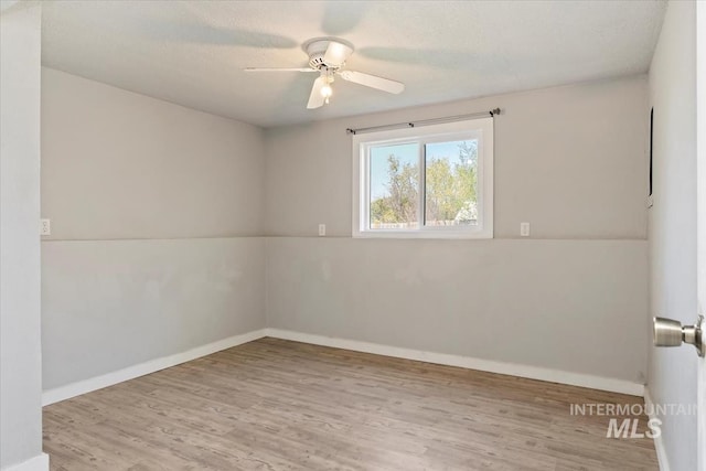unfurnished room featuring ceiling fan, wood finished floors, and baseboards
