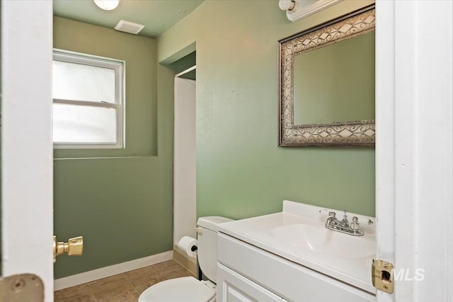 bathroom with tile patterned flooring, toilet, vanity, baseboards, and visible vents