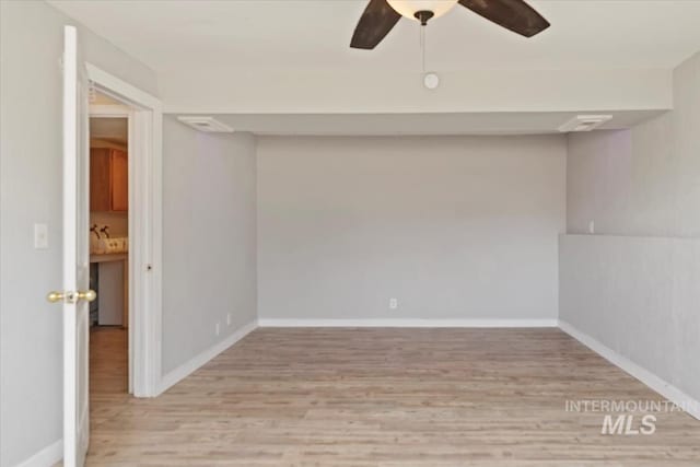spare room featuring a ceiling fan, wood finished floors, and baseboards