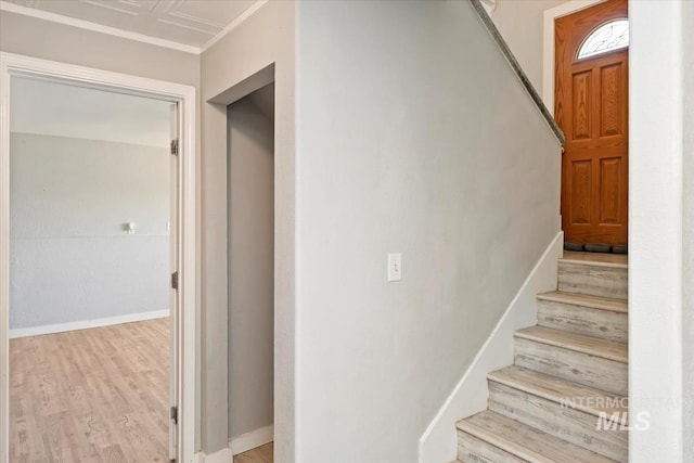 staircase featuring wood finished floors and baseboards