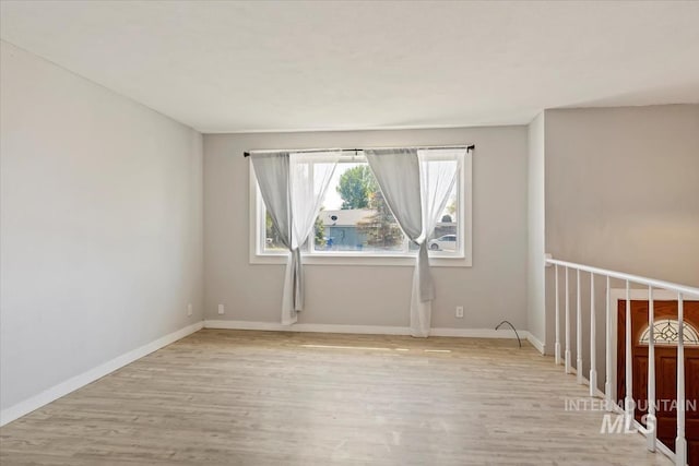 empty room featuring baseboards and wood finished floors
