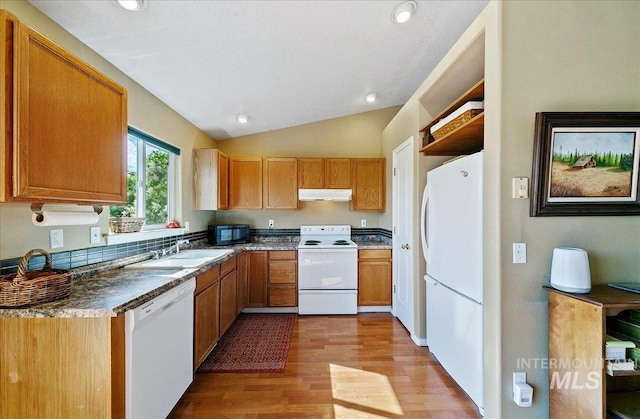 kitchen with a sink, white appliances, lofted ceiling, light wood-type flooring, and under cabinet range hood