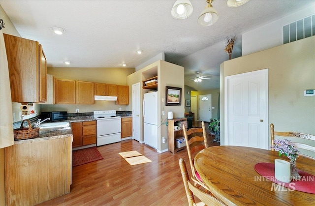 kitchen with visible vents, lofted ceiling, white appliances, light wood-type flooring, and under cabinet range hood