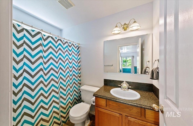 bathroom with toilet, visible vents, curtained shower, and vanity