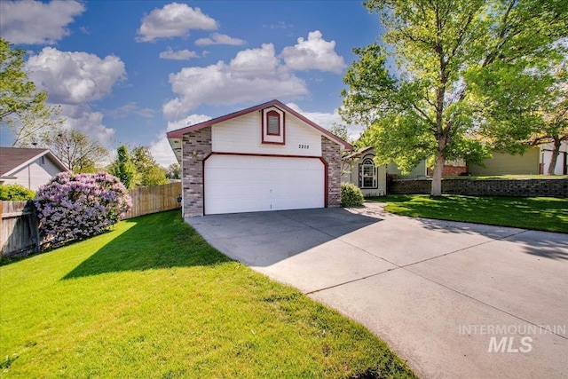 view of front of property with fence, an attached garage, brick siding, a front yard, and driveway