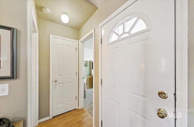 foyer featuring baseboards and light wood-style flooring