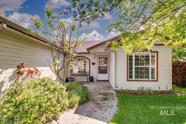 view of exterior entry with a lawn