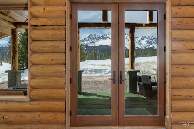 doorway to outside with rustic walls, a water and mountain view, and french doors